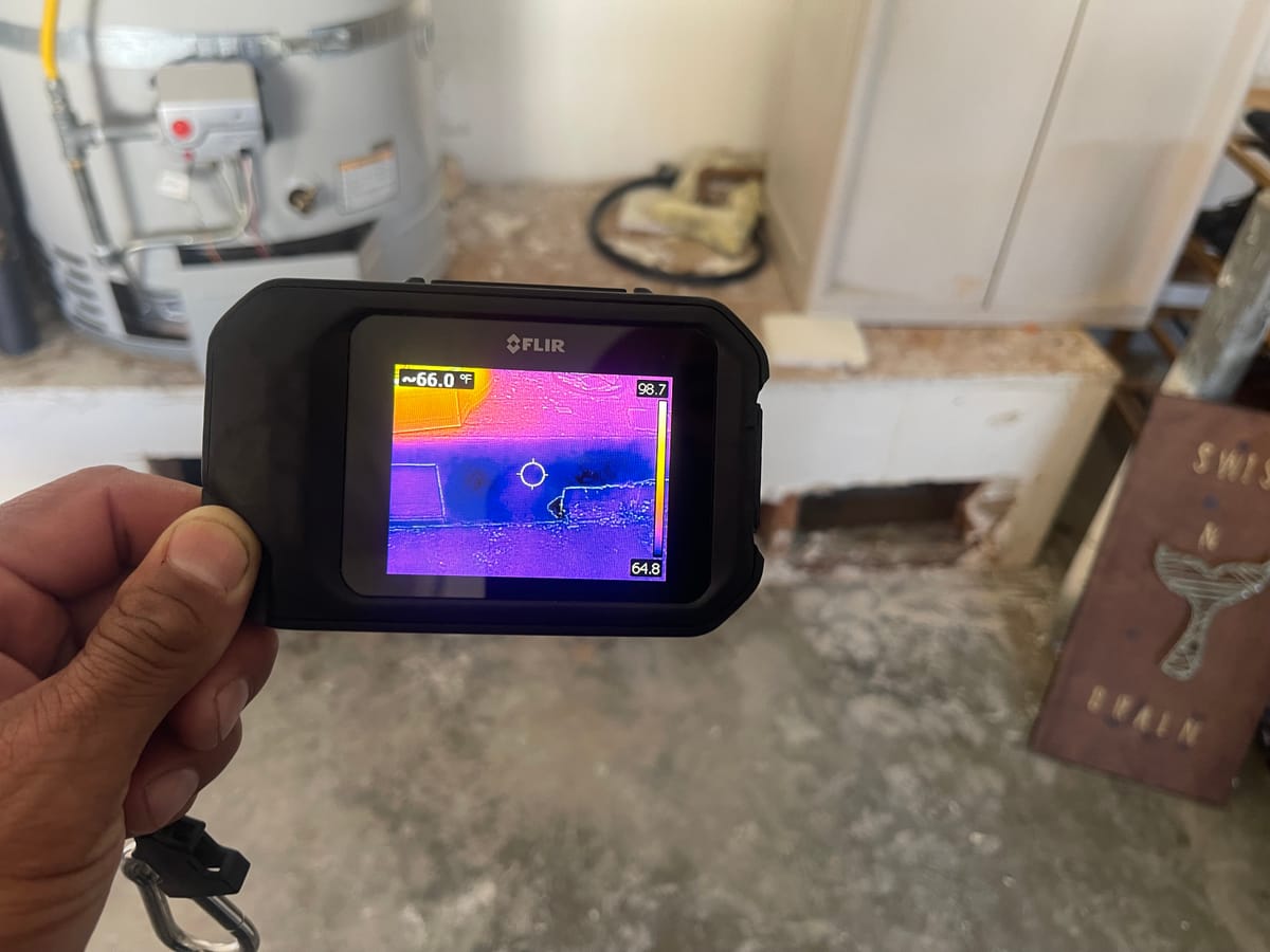 Apex technician scanning for hidden moisture with a thermal camera